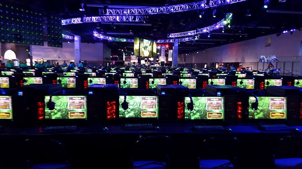 Rows of gaming PCs running World of Warcraft with Logitech G headsets at a large event hall